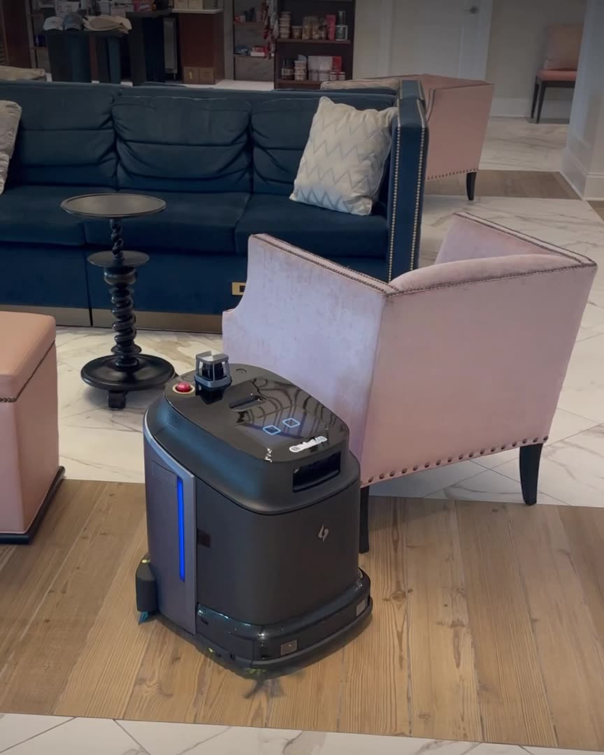 Partner-network footage (Gausium): a Phantas cleaning robot on the wood and marble floor of a hotel lounge