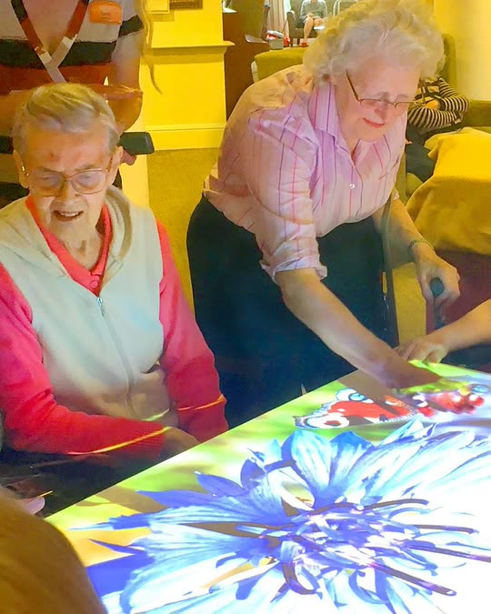 Residents playing a game on the Mobii interactive activity table
